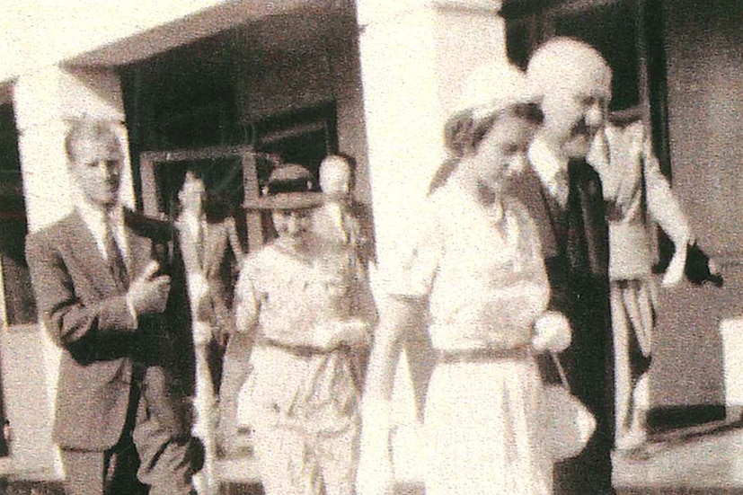 Black and white picture of Queen Elizabeth II walking through Broken Hill with an entourage in 1954.