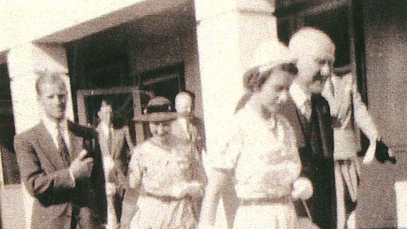 Black and white picture of Queen Elizabeth II walking through Broken Hill with an entourage in 1954.