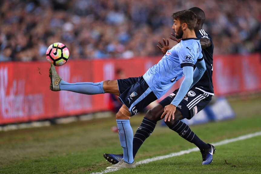 Milos Ninkovic keeps control of the ball despite pressure from Jason Geria of the Victory.