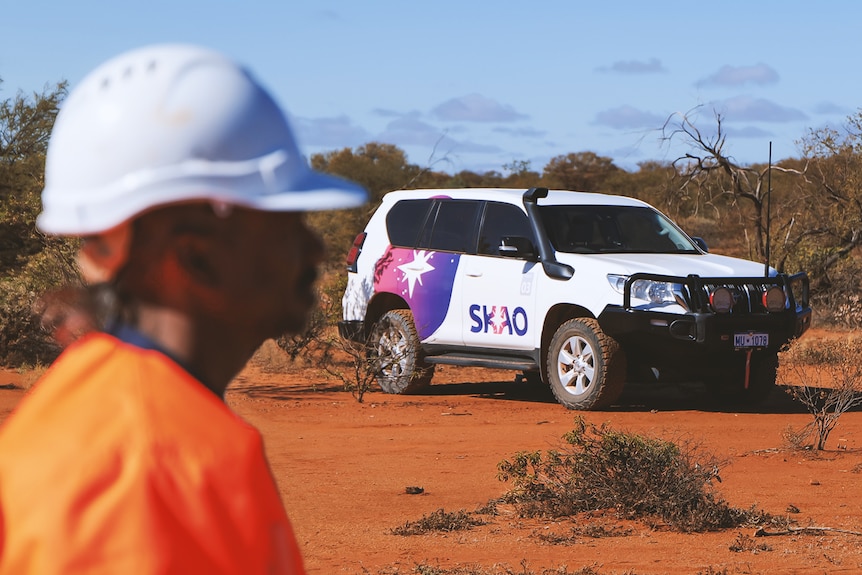 SKAO branded 4wd with a worker blurred in the foreground.