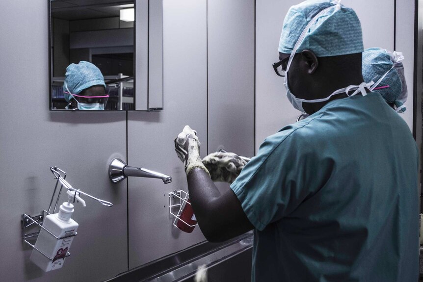 Man and woman in surgery scrubs washing their hands to depict story about bullying of medical students.