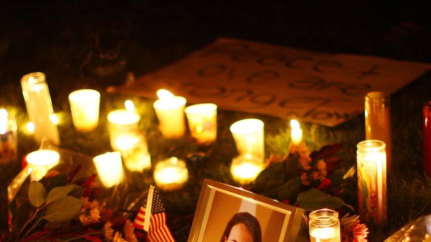 A picture of Gabrielle Giffords is surrounded by candles