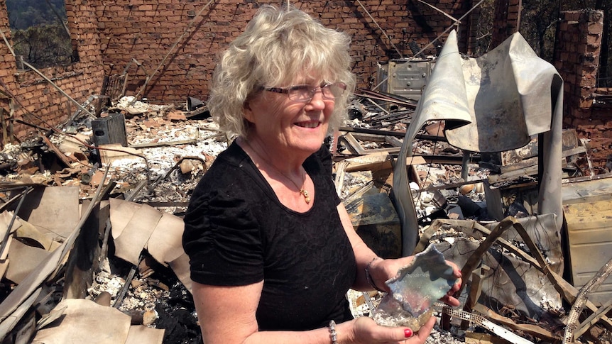 Winmalee resident Jean Cooling goes through the remains of her home