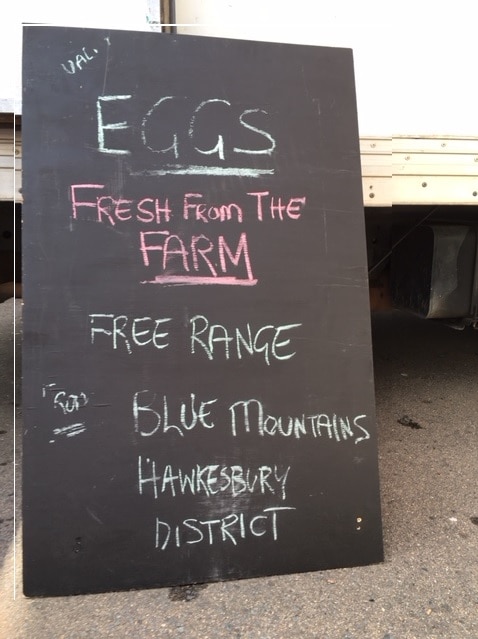 A sign at Bondi markets advertising local produce sold by Patrick Bhushan from his family's farm and other western Sydney farms.