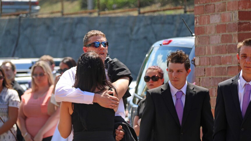 Mourners at the funeral of Hobart woman Sarah Paino comfort her partner Danial Stirling.