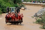 Rescue workers are transported into an earthquake zone on a front loader in Zhaotong in China's Yunnan province.