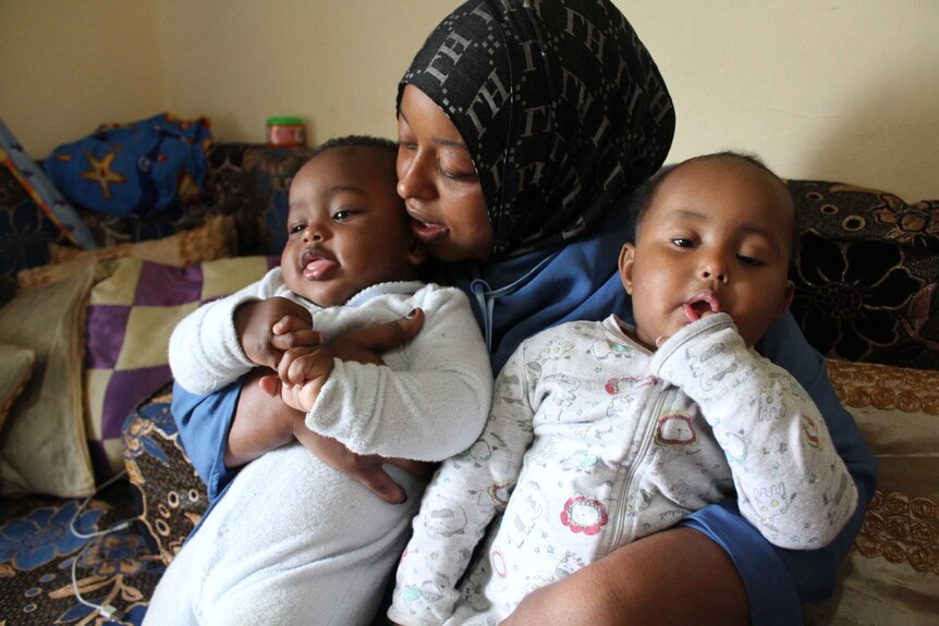 Single mother of five, Fartun, cuddles her twin babies