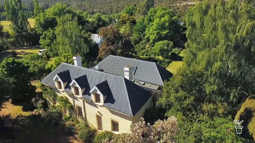 Aerial shot of large house and garden surrounded by bushland