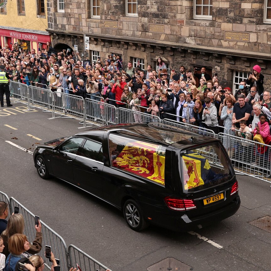 A hearse carrying the coffin of the Queen travels down the Royal Mile.