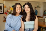 A woman with dark hair smiles with a girl with dark hair 