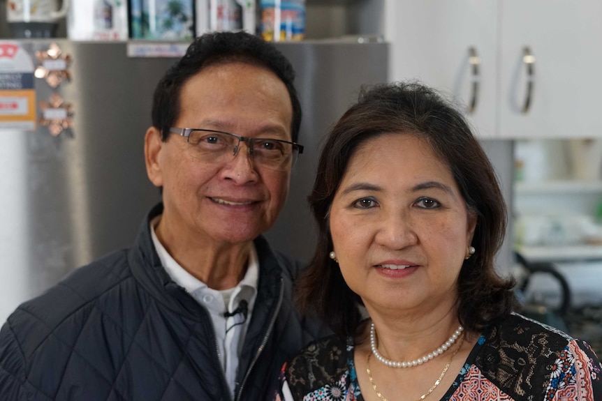 Louie and Nida Tolentine stand in a kitchen smiling at the camera.