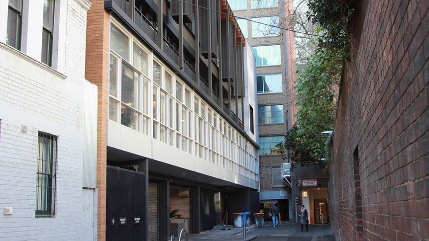 The Lyceum Club is a three or four story mid-century building with wall-to-wall windows in a Melbourne lane.