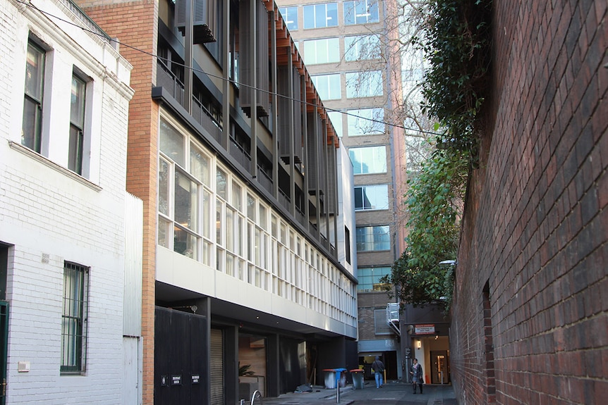 The Lyceum Club is a three or four story mid-century building with wall-to-wall windows in a Melbourne lane.