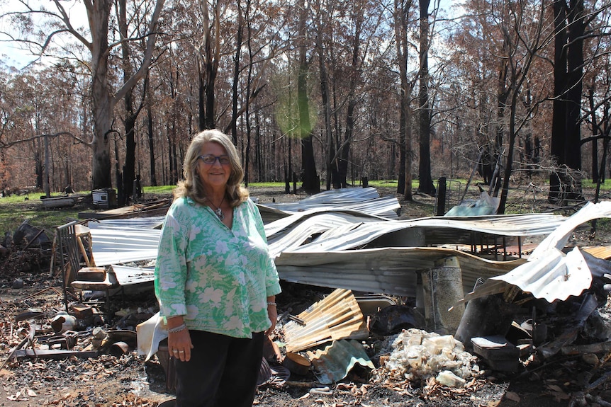 Esther Koamer  stands in front of a shed which has been destroyed in the bushfire.