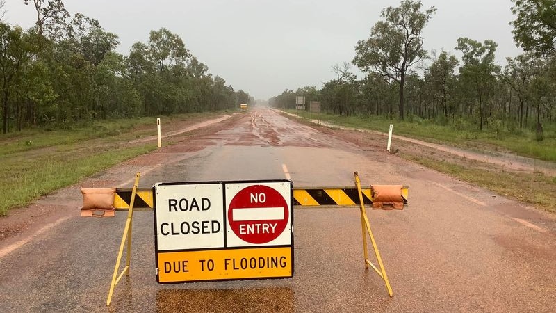 A flooded road and a sign saying Road closed due to flooding.