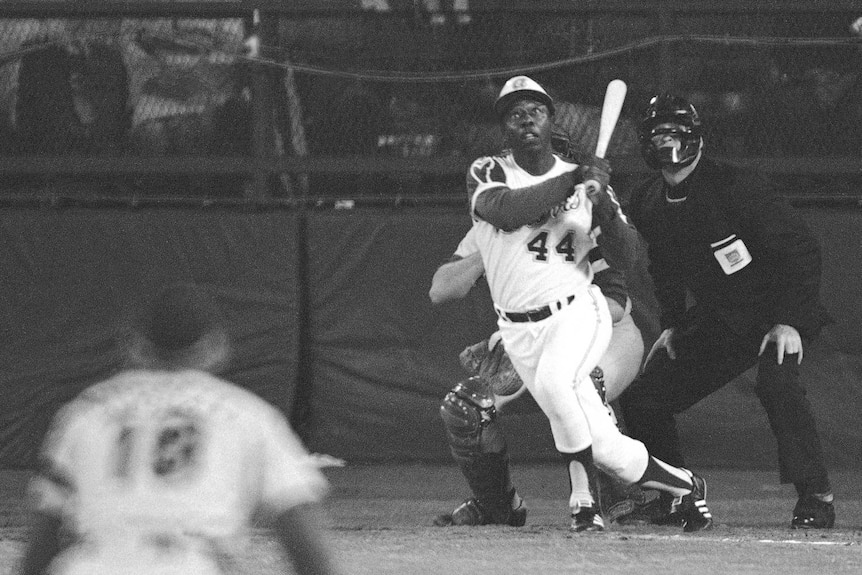 Hank Aaron watches the flight of a ball as he hits a home run for the Atlanta Braves against the LA Dodgers in 1974.