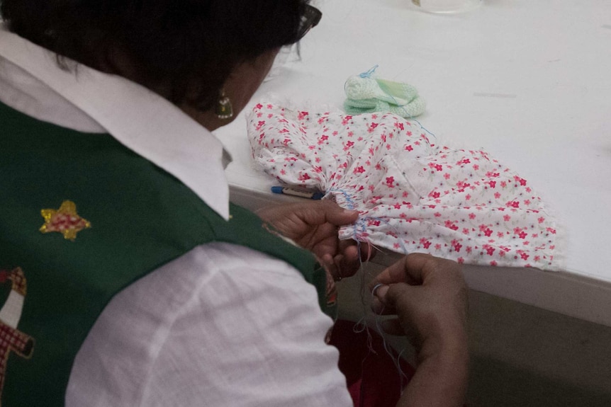 Woman smocking a wee care gown