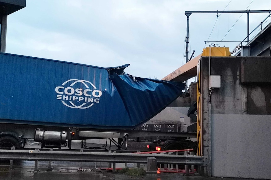 A blue container is partially crushed after hitting the top of the Napier Street Bridge.