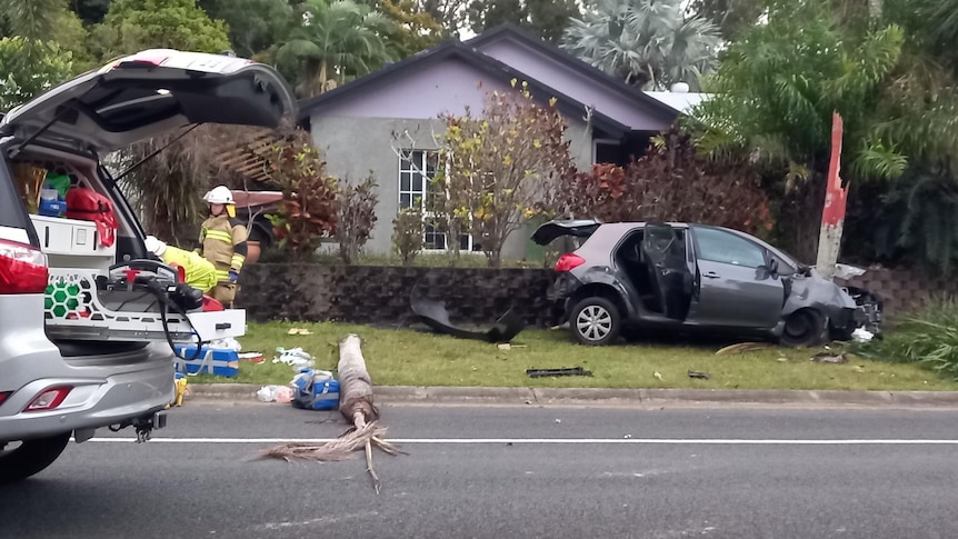 Emergency services near a car wreck on a suburban street.