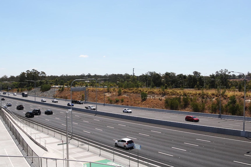 Traffic on M1 at Rochedale South, south of Brisbane, showing site land of new bus station and busway to be built