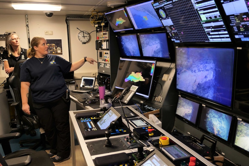 A room inside a ship filled with computer screens.