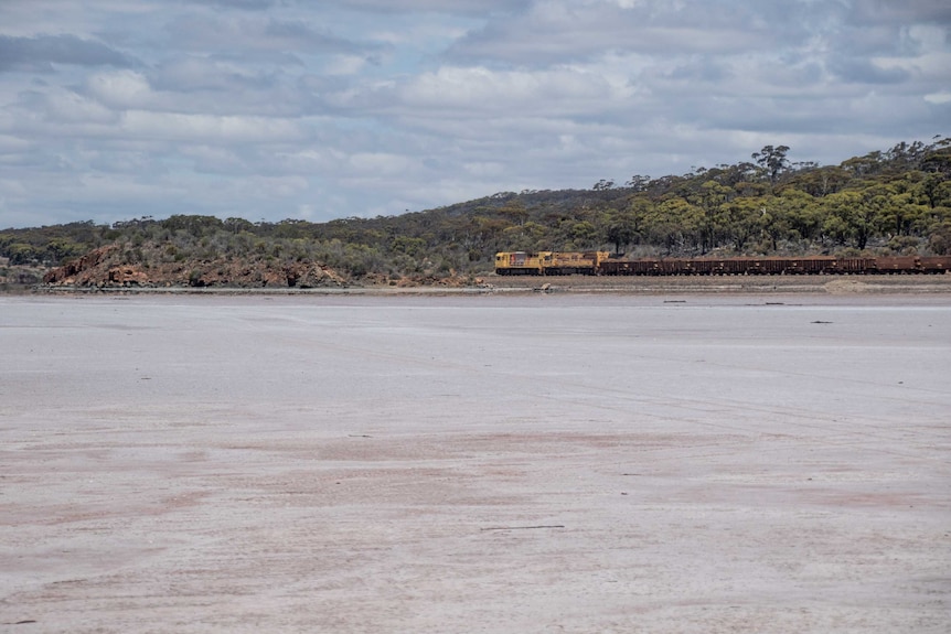 A train passing by a salt lake.