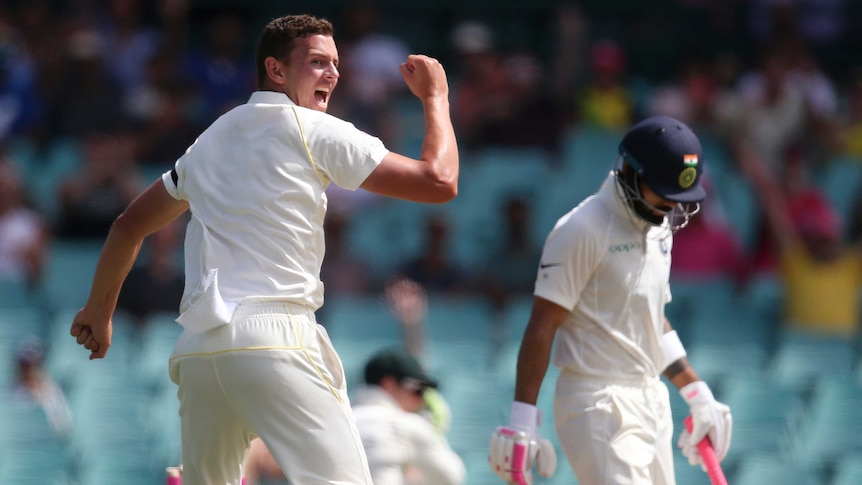 Australia fast bowler Josh Hazlewood looks over his shoulder and pumps his fist to celebrate dismissing Virat Kohli in a Test.