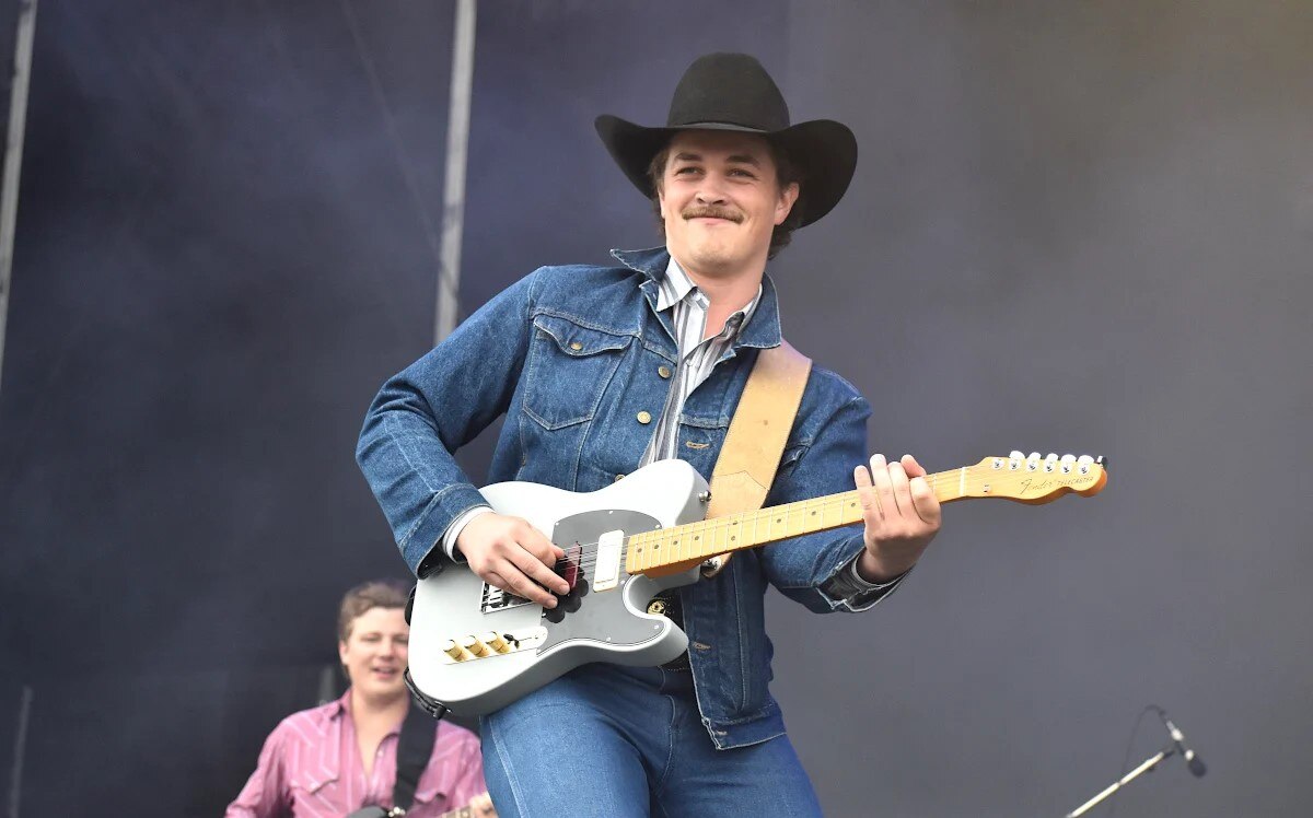 Zach Top playing guitar live in double denim and cowboy hat