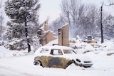 Snow covers a burned out Mini Cooper car in Louisville.