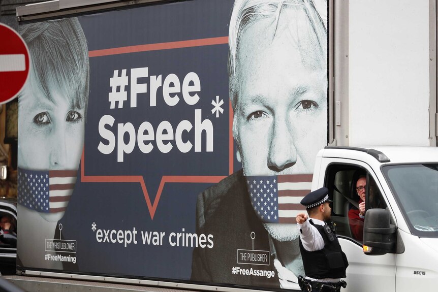 A man drives a truck with the images of whistleblower Chelsea Manning and Wikileaks founder Julian Assange on its side.