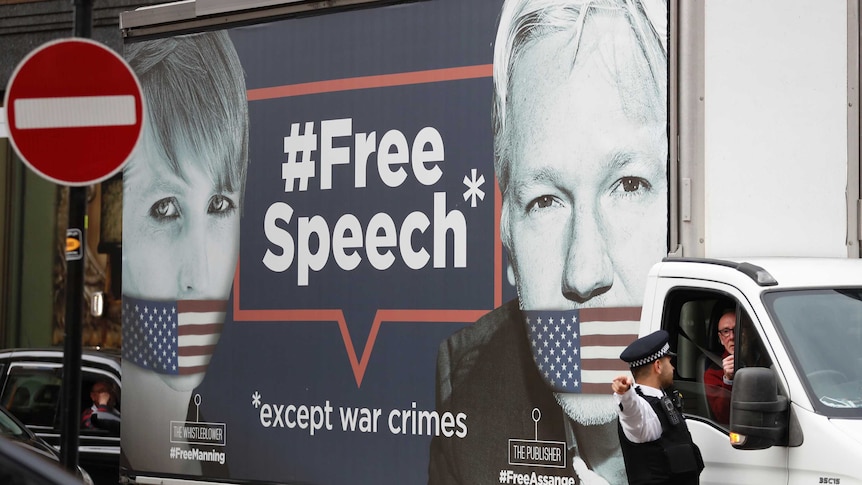 A man drives a truck with the images of Wikileaks founder Julian Assange and whistleblower Chelsea Manning on its side.