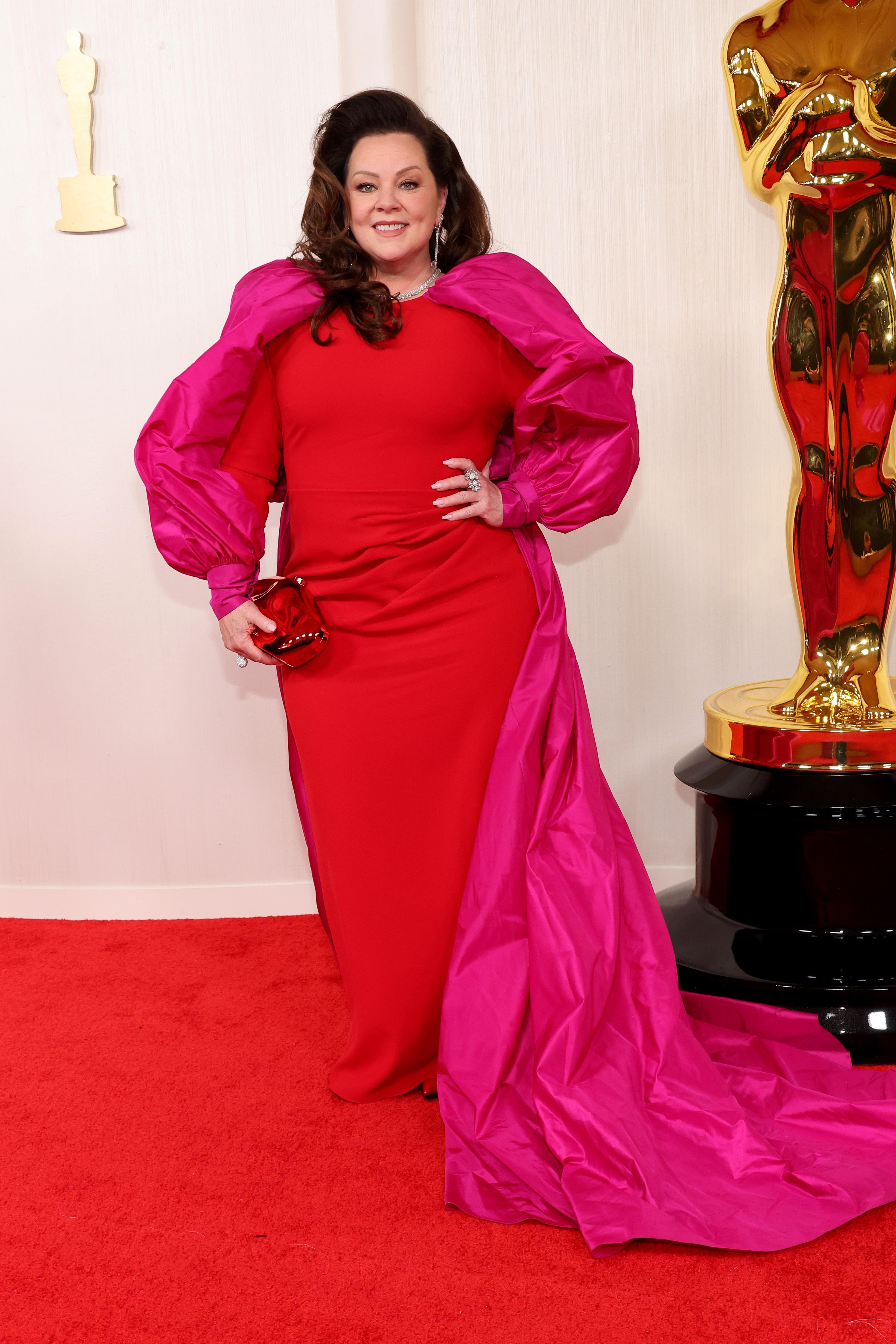 Melissa McCarthy con un vestido rojo y rosa en la alfombra roja de los Oscar