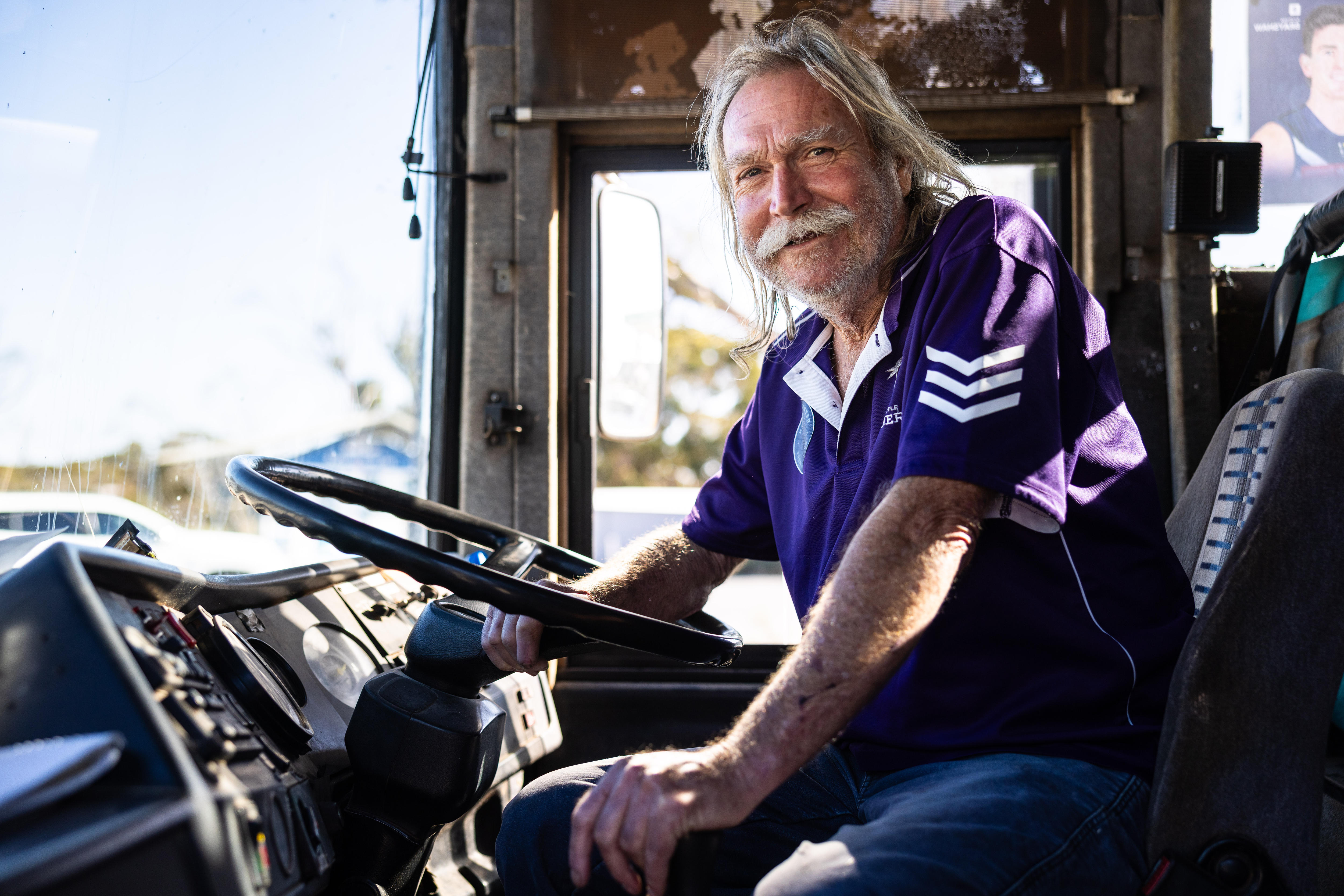 A bus driver wearing Fremantle Dockers t-shirt