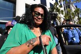 Uiatu "Joan" Taufua outside court with sunglasses and a green blouse.
