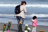A little girl and her mother pray on the Arahama beach for the victims of 2011's Japanese earthquake and tsunami