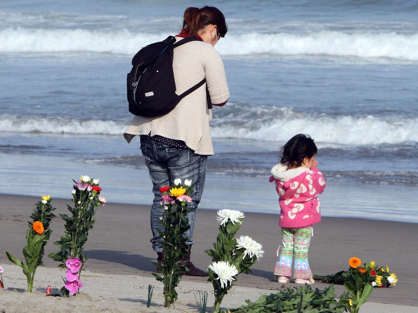 A little girl and her mother pray on the Arahama beach for the victims of 2011's Japanese earthquake and tsunami