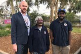 Aboriginal Health Services executive Kurt Towers stands next to two traditional Aboriginal healers