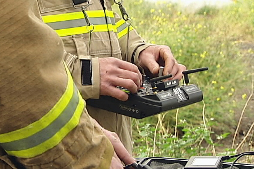 Close up of man's hands holding the operating panel for a drone.