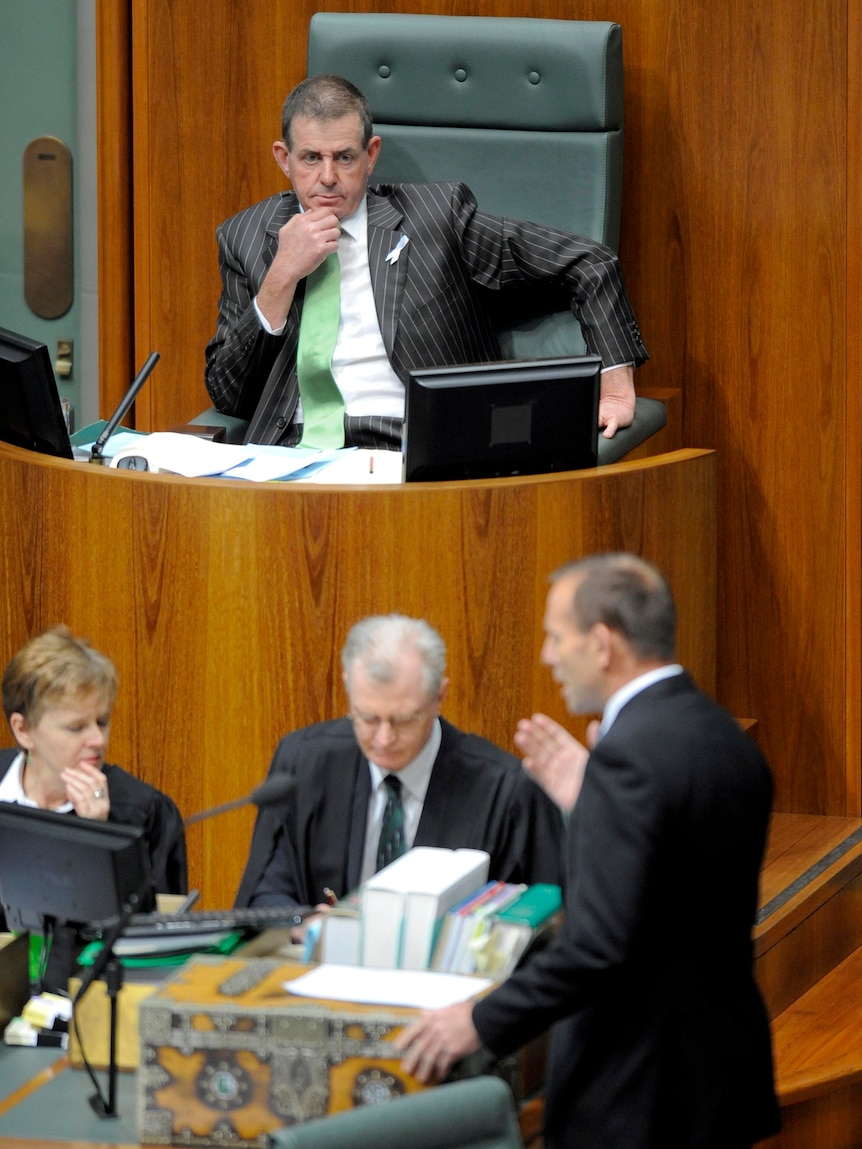 The newly elected Speaker, Peter Slipper, listens to Tony Abbott.
