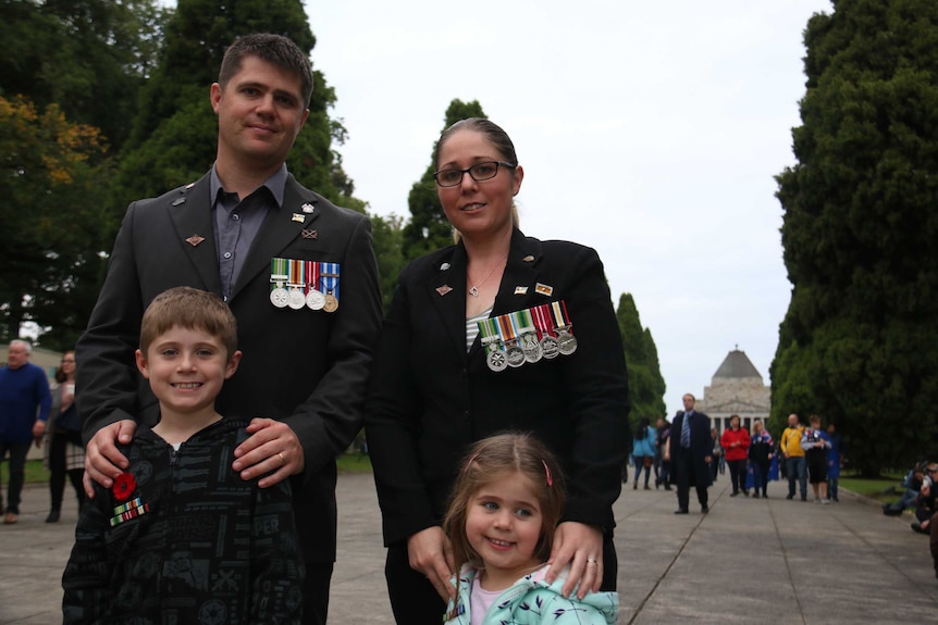 A father and mother who both previously served the country stand with their two children near the shrine of remembrance