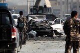 Afghan security force members inspect the site of the suicide car bombing.