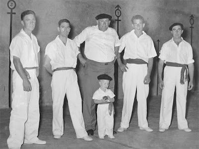 Five men and a child dressed in white in a black and white photo.