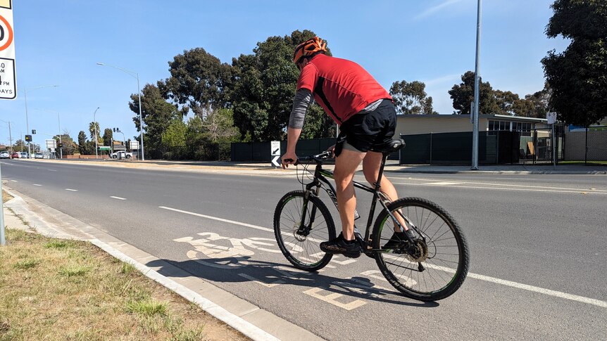A cyclist rides in a bike lane on a road in Shepparton, Victoria.