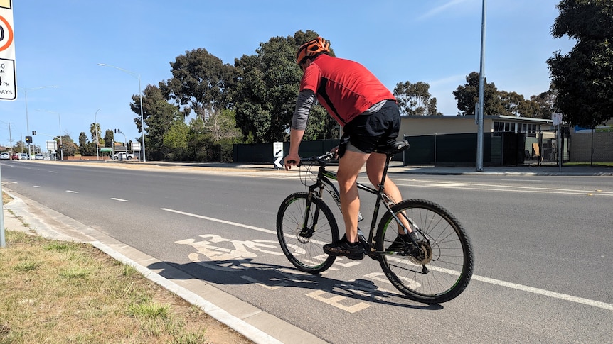 A cyclist rides in a bike lane on a road in Shepparton, Victoria.