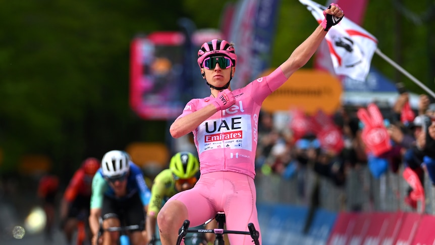 Tadej Pogačar salutes as he crosses the finish line in first place in stage eight of the Giro d'Italia.