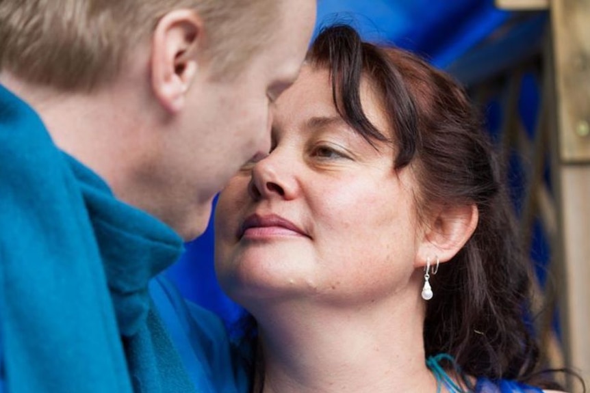 Woman with earring looking lovingly at a man side-on