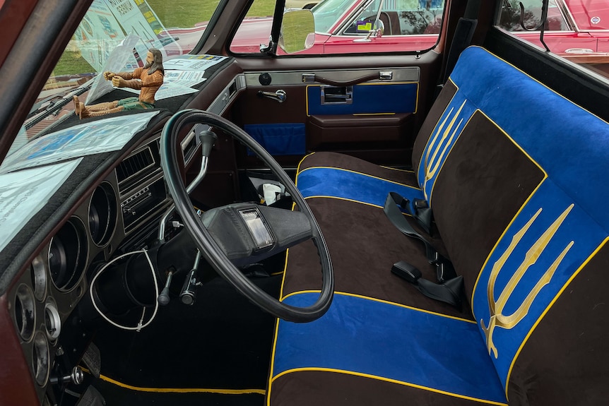 The interior of a car that has trident-pattern seat covers.