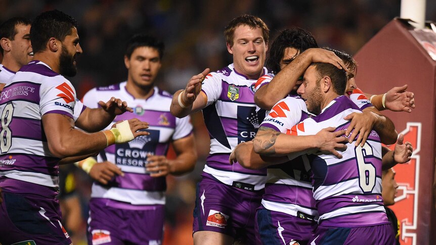 Blake Green of the Storm, (right), celebrates with team mates after scoring a try