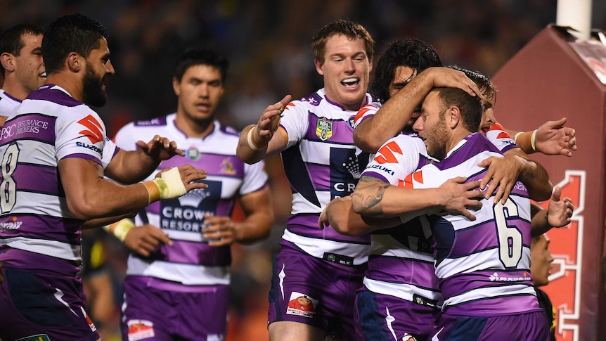 Blake Green of the Storm, (right), celebrates with team mates after scoring a try