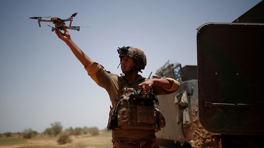 A soldier releases a drone.